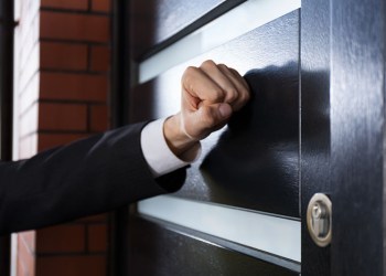 Process server hand knocking on door