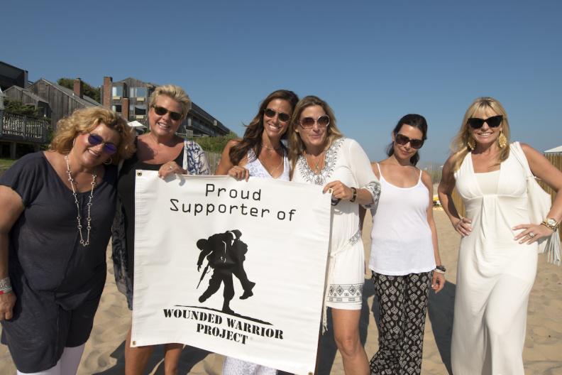 Alissa Straino of Inside Out, with the women behind the event, holding a Wounded Warrior banner, working to make a difference.