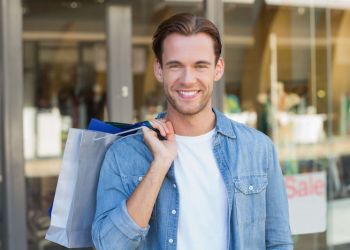 portrait of a smiling man with shopping bags at the mall