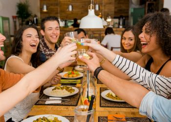 group of friends toasting and looking happy at a restaurant