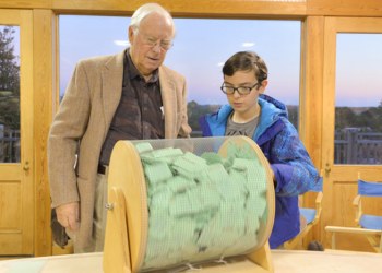 East End Classic Boat Society President Ray Hartjen watches Frank Piekarz, 11, pick the winner.