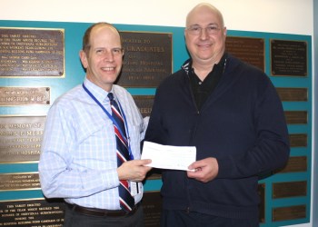 Southampton Hospital President and CEO Robert S. Chaloner accepts a check from Hamptons Health Society Chairman Peter Michalos.