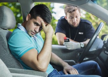 Man looking embarrassed in his car as BBITF cop checks his wealth and learns he's too poor to enter the Hamptons