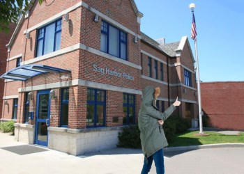 Woman in heavy winter coat doing a thumbs up outside Sag Harbor Police headquarters