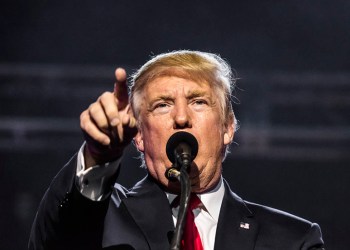 Donald Trump pointing behind microphone