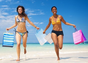 34401443 - women with shopping bags on a tropical beach.