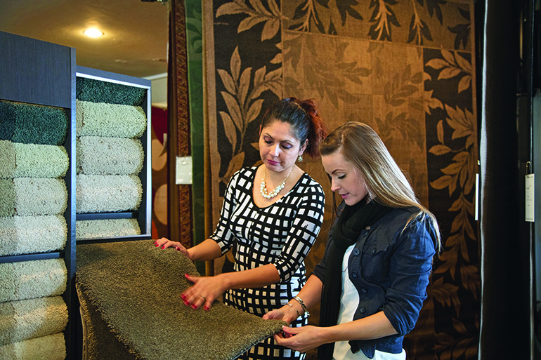 Woman shopping for carpeting and flooring in a home interiors store.