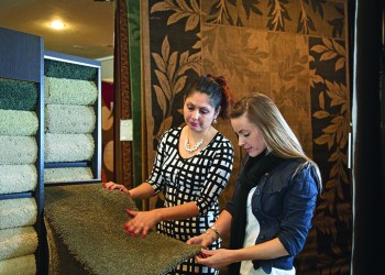 Woman shopping for carpeting and flooring in a home interiors store.