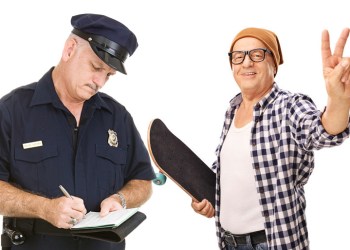 Policeman ticketing old skateboarder