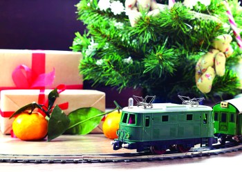 little old toy train on the track and with a motor under the Christmas tree decorated