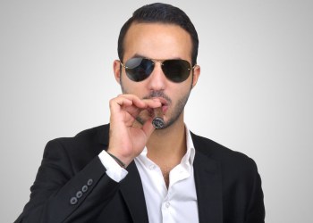 Man smoking cigar while wearing sunglasses