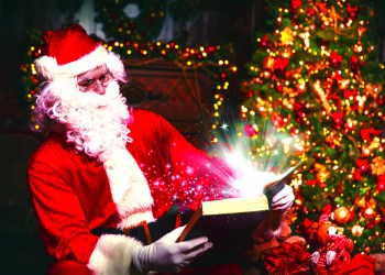 Santa Claus at Christmas with glowing magical book