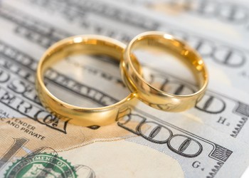 Close-up Of Wedding Ring On Us Dollar