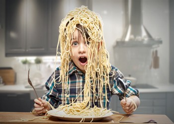 Surprised boy with pasta on the head