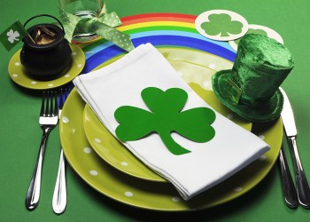 st patricks day party table dinner setting with rainbow, leprechaun hat and shamrocks