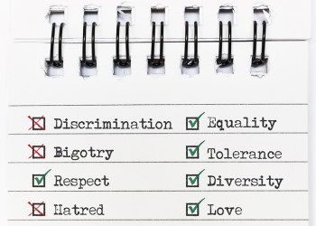 Spiral notebook page with green checks on the words Equality, Tolerance, Diversity, Love and Respect, and red Xs on Discrimination, Bigotry and Hatred