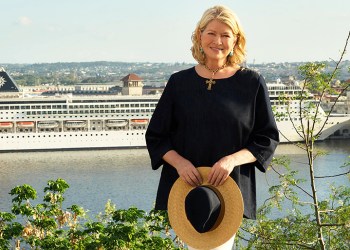 Martha Stewart stands in front of MSC Cruises cruise ship in a beautiful setting