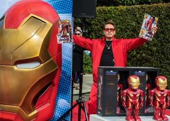 Robert Downey Jr. holds up toys at the Avengers Universe Unites event