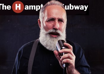 Hamptons Subway announcer Harold Gooding on microphone in front of Hamptons Subway sign