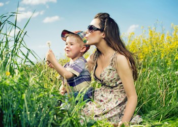 happy family having a lot of fun with dandelions, unaware of the ticks looming around them