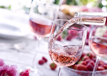 Close up of Rose wine being poured at a picnic setting.