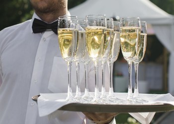 Waiter serving champagne on a tray outdoors