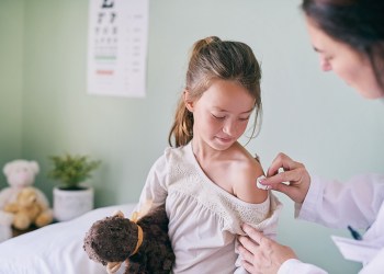 Shot of a pediatrician cleaning her young patients arm with a cotton ball