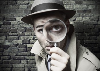 funny vintage detective looking through a magnifier