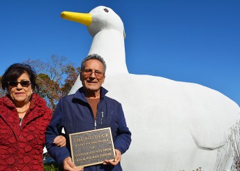 Pouran and Kia Eshghi holding the plaque honoring their gift of The Big Duck to Suffolk County