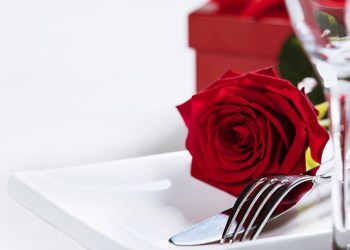 Valentine's Day or Romantic dinner concept. Valentine day or proposal background. Close up view of restaurant table with romantic table place setting. Copy space