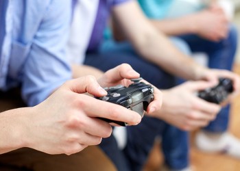 close up of friends playing video games at home