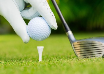 Close up view of golf ball on tee on golf course