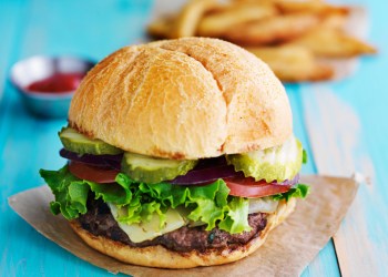 cheeseburger with fries and ketchup on rustic table top