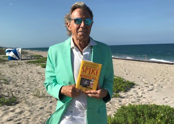 Bill Boggs holding Spike the Wonder Dog book on Hamptons beach