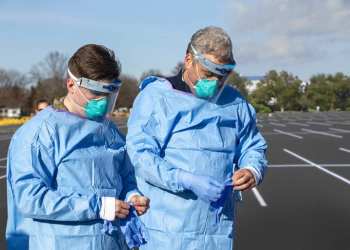 ASSISTANT DEAN FOR CLINICAL INTEGRATION JOSHUA MILLER, MD, MPH INSTRUCTS MEDICAL STAFF ON THE PROCEDURES TO TAKE IN SCREENING DRIVE UP PATIENTS AT THE COVID-19 DRIVE-THRU TESTING FACILITY. PHOTO BYSTONY BROOK UNIVERSITY HOSPITAL