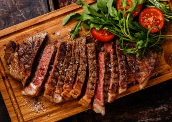 steak and salad with tomatoes and arugula close-up