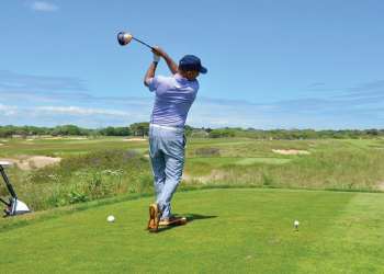 Man hitting golf ball at Maidstone Club in the Hamptons