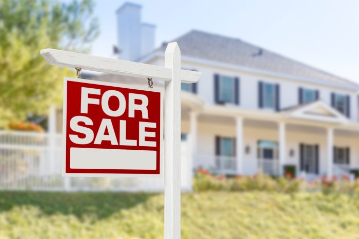 Home For Sale Real Estate Sign in Front of Beautiful New House.