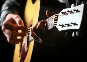 Young men playing the guitar with black background