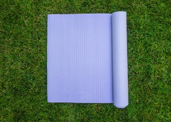 Purple yoga Mat on the grass. Mat for yoga, Pilates or fitness