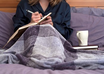 Woman journaling in bed