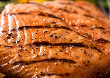 Close up of a grilled salmon filet on charcoal grill with asparagus, hot charcoal, fire and smoke. Please see my portfolio for other food and drink images.