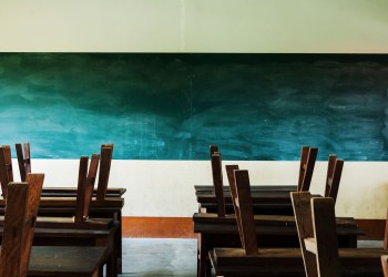 chair and table in class room with black board background, no student, school closed concept