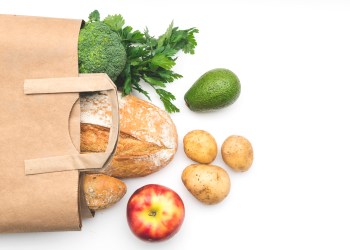 Full paper bag of different health food on white