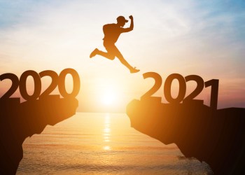 Silhouette man jump from 2020 to 2021 on cliff with sunlight for change and welcome the new year.