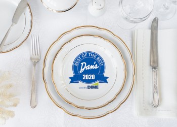 Beautifully decorated table with white plates, glasses, antique cutlery and white coral on luxurious tablecloths