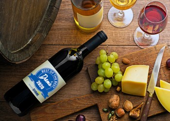 Glasses and bottles of red wine and white wine on wooden background