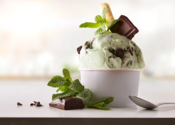 Mint choco ice cream cup on white table homemade with kitchen background. Horizontal composition. Front view.