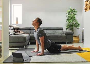 Man practicing yoga at home