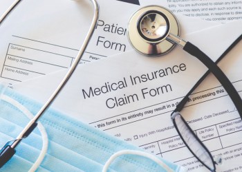 Medical Insurance claim form with stethoscope and surgical face mask.